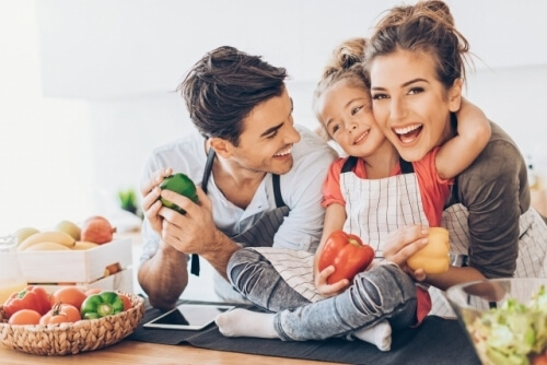 Une famille heureuse dans une cuisine avec des fruits et légumes frais